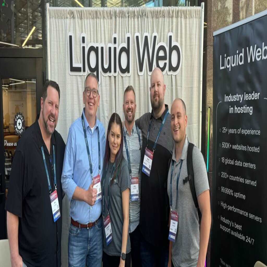 The Liquid Web field team posing for a picture in front of their booth