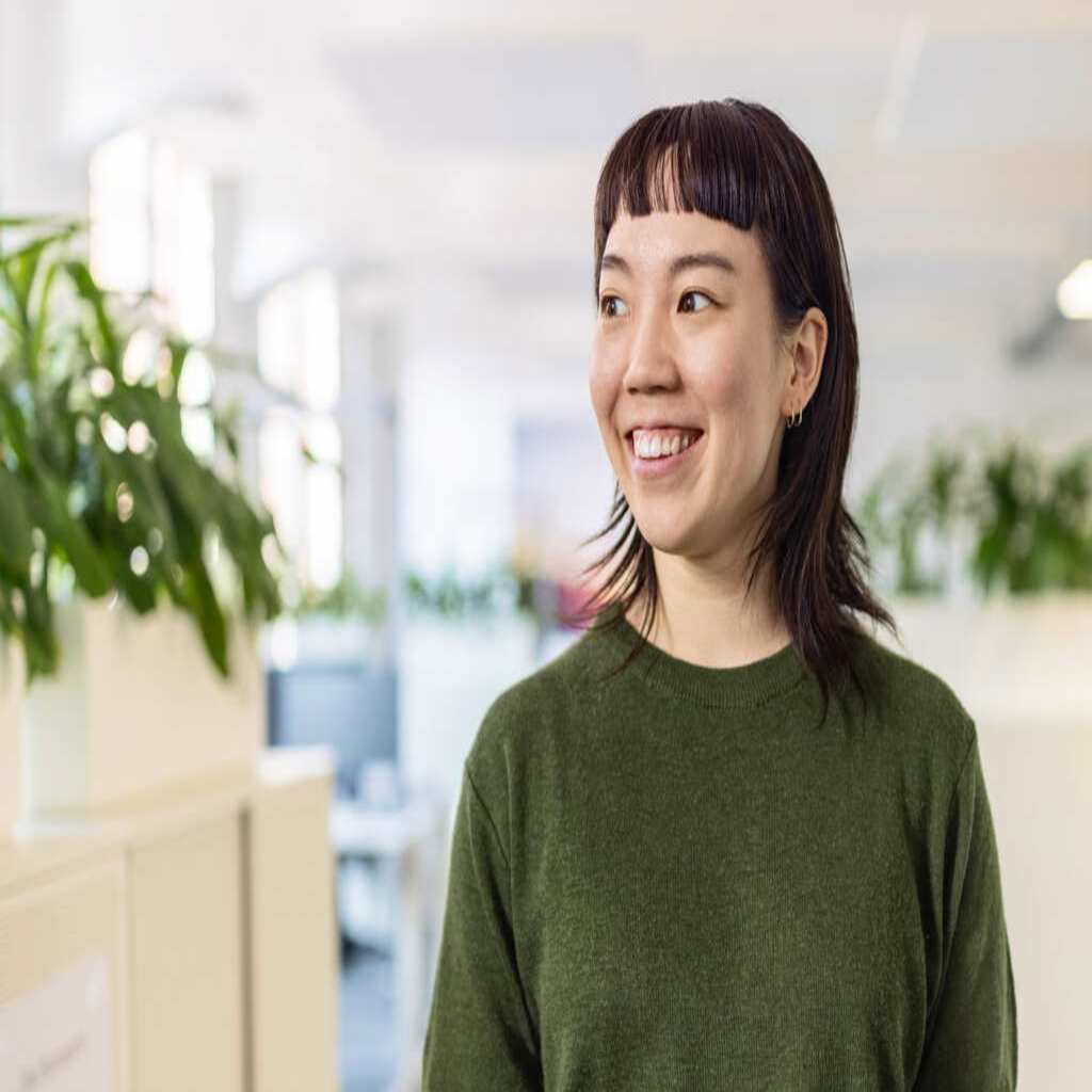 A hosting support representative smiles in a sunny office environment