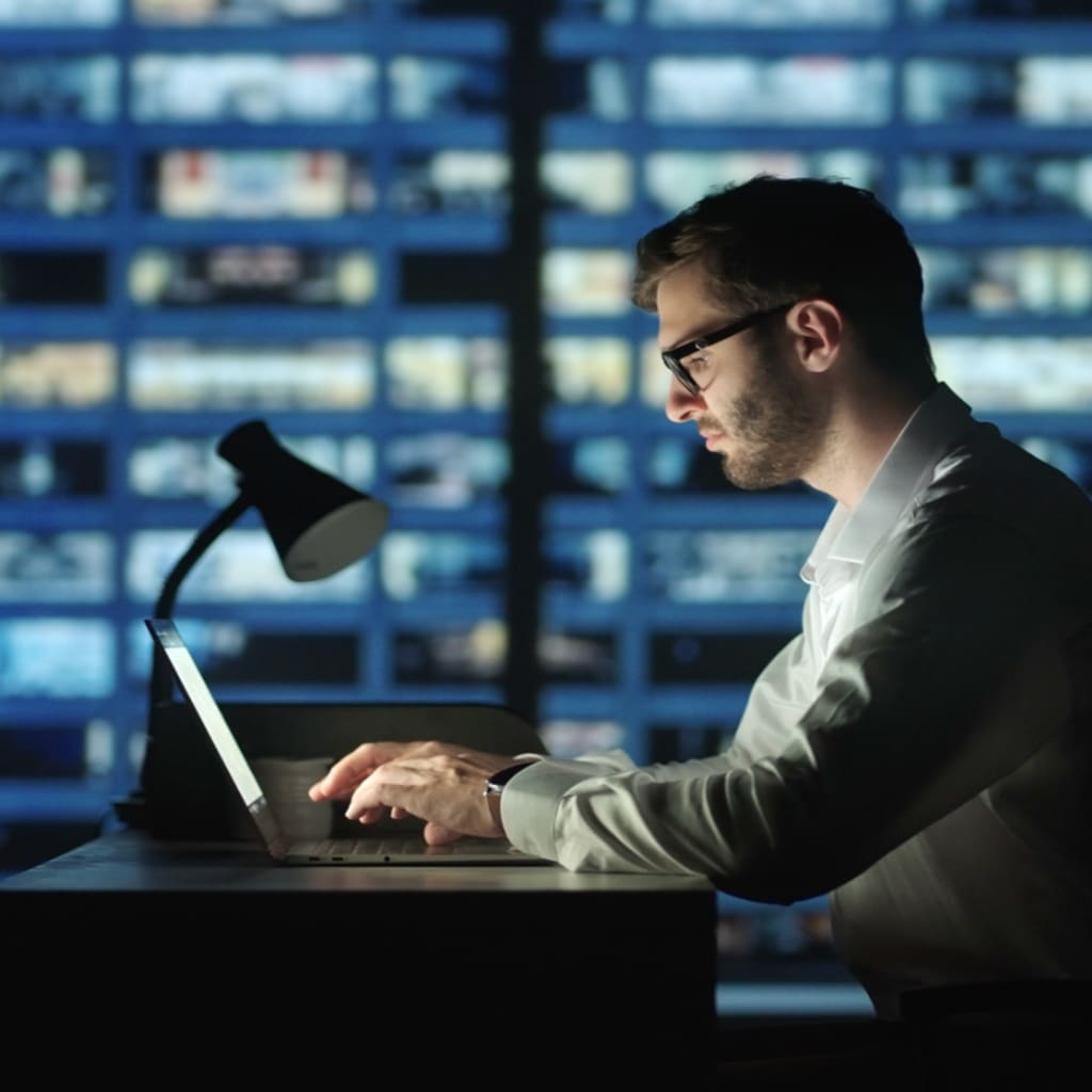 IT Worker in the office after hours monitoring network and working hard around the clock
