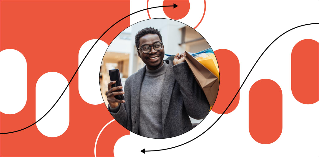Image of a man holding a shopping bag and cell phone