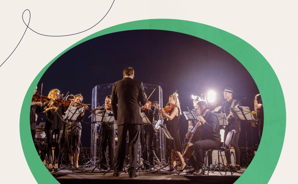 A picture of an orchestra with a conductor