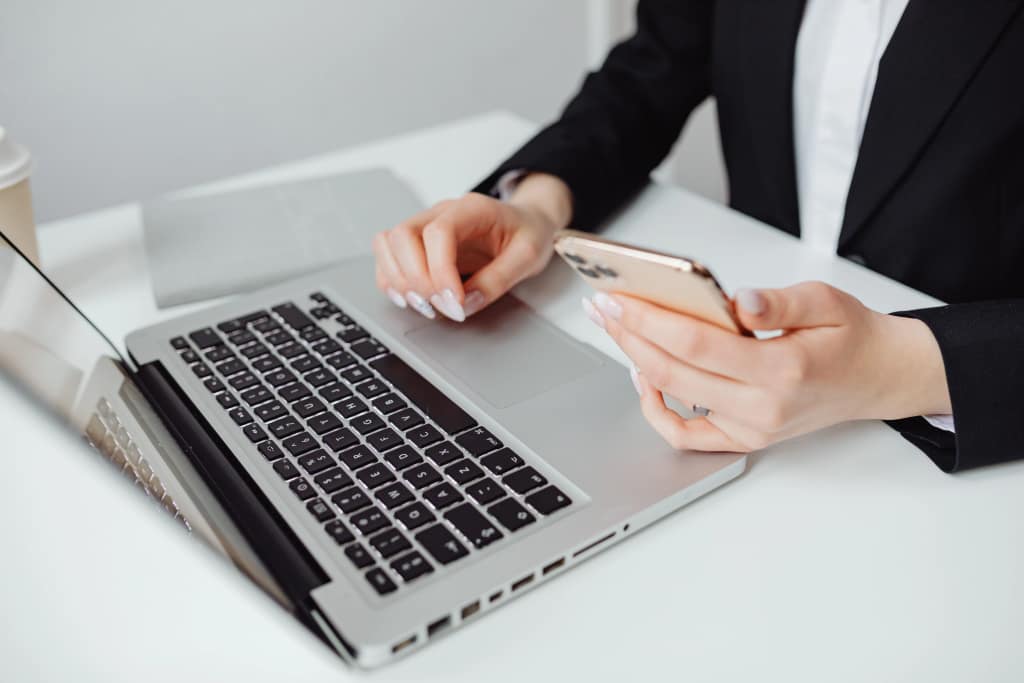 Person using a laptop and smartphone for everyday digital tasks