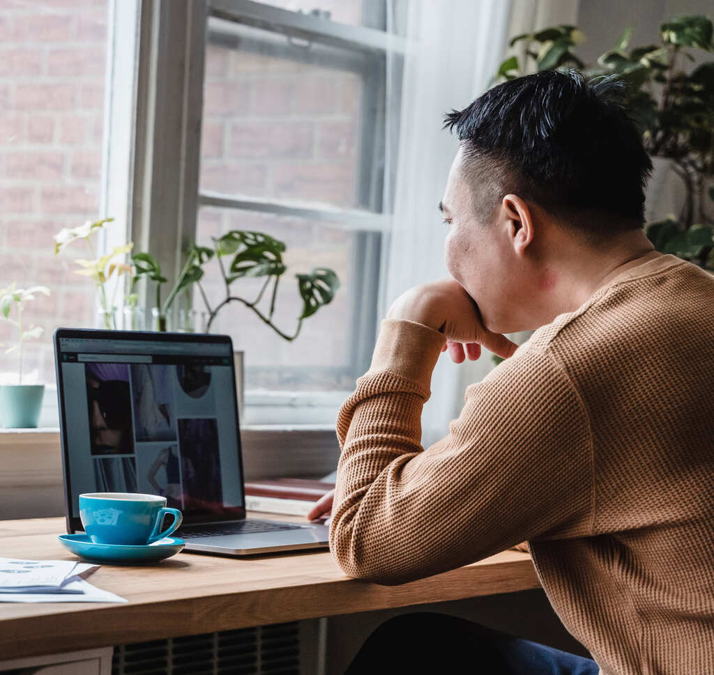 a freelancer looks at his computer as he builds a website