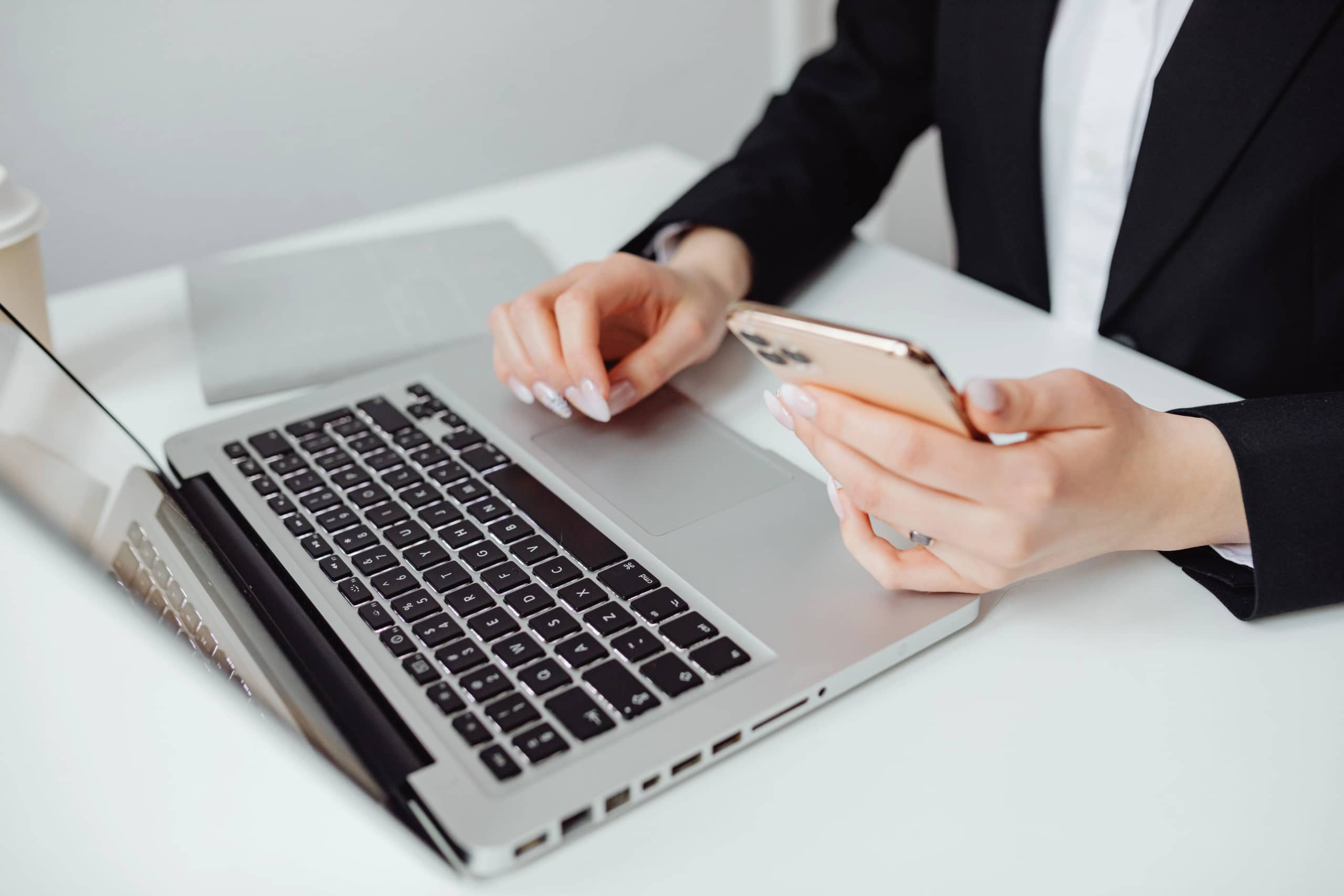 Person using a laptop and smartphone for everyday digital tasks