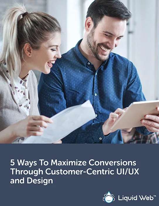 A girl and guy UI/UX designers laughing while the guy shows her something on his tablet
