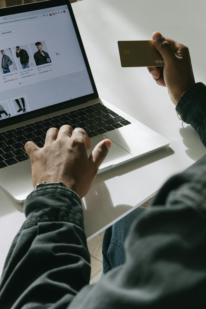 Person with Credit Card in hand looks at online store ready to make an ecommerce purchase