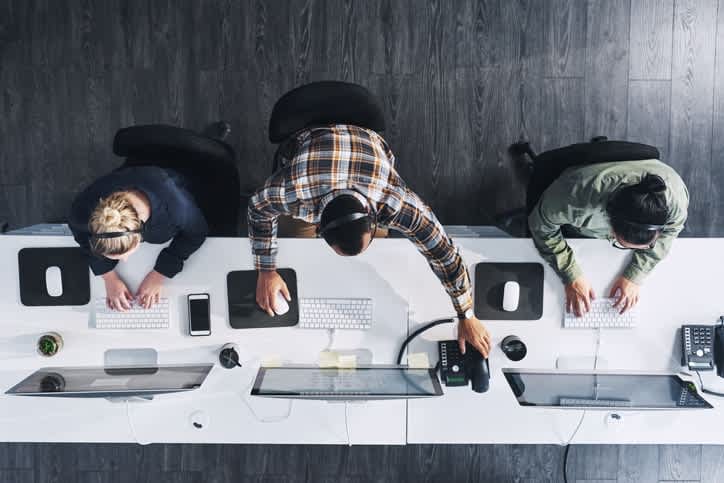 An overhead view of people on a computer.