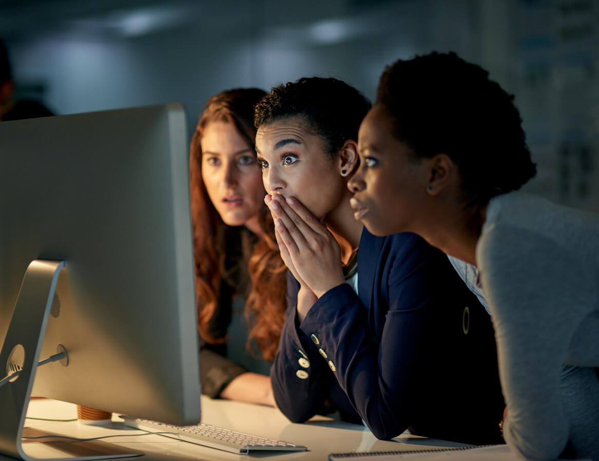 Group of 3 professional women in front of a screen after a Data Breach.