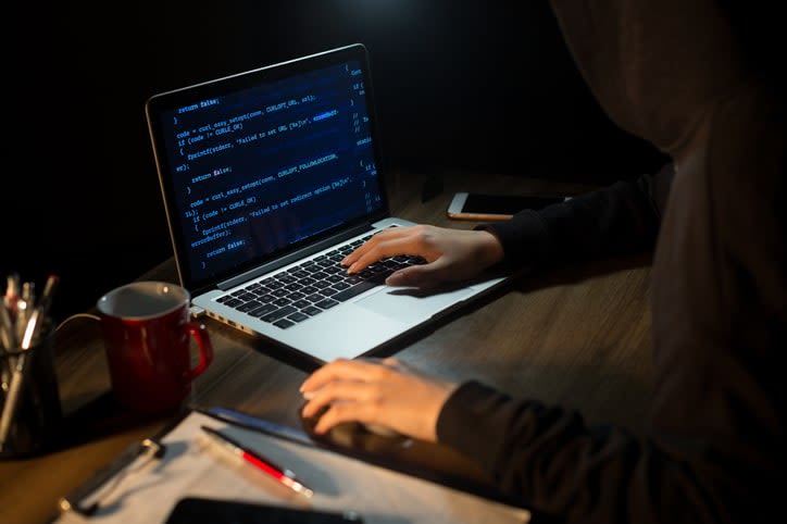 A person coding on a laptop