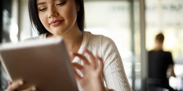 Woman typing on tablet