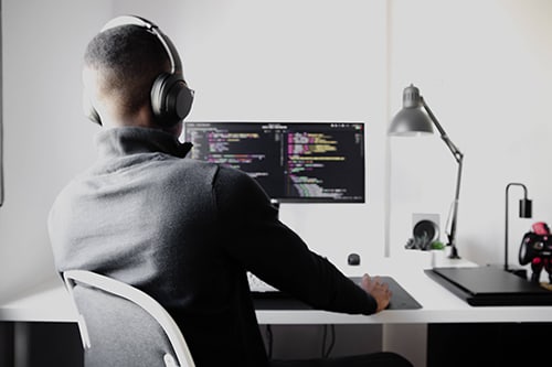 A developer sits at his desk in front of his computer refactoring code