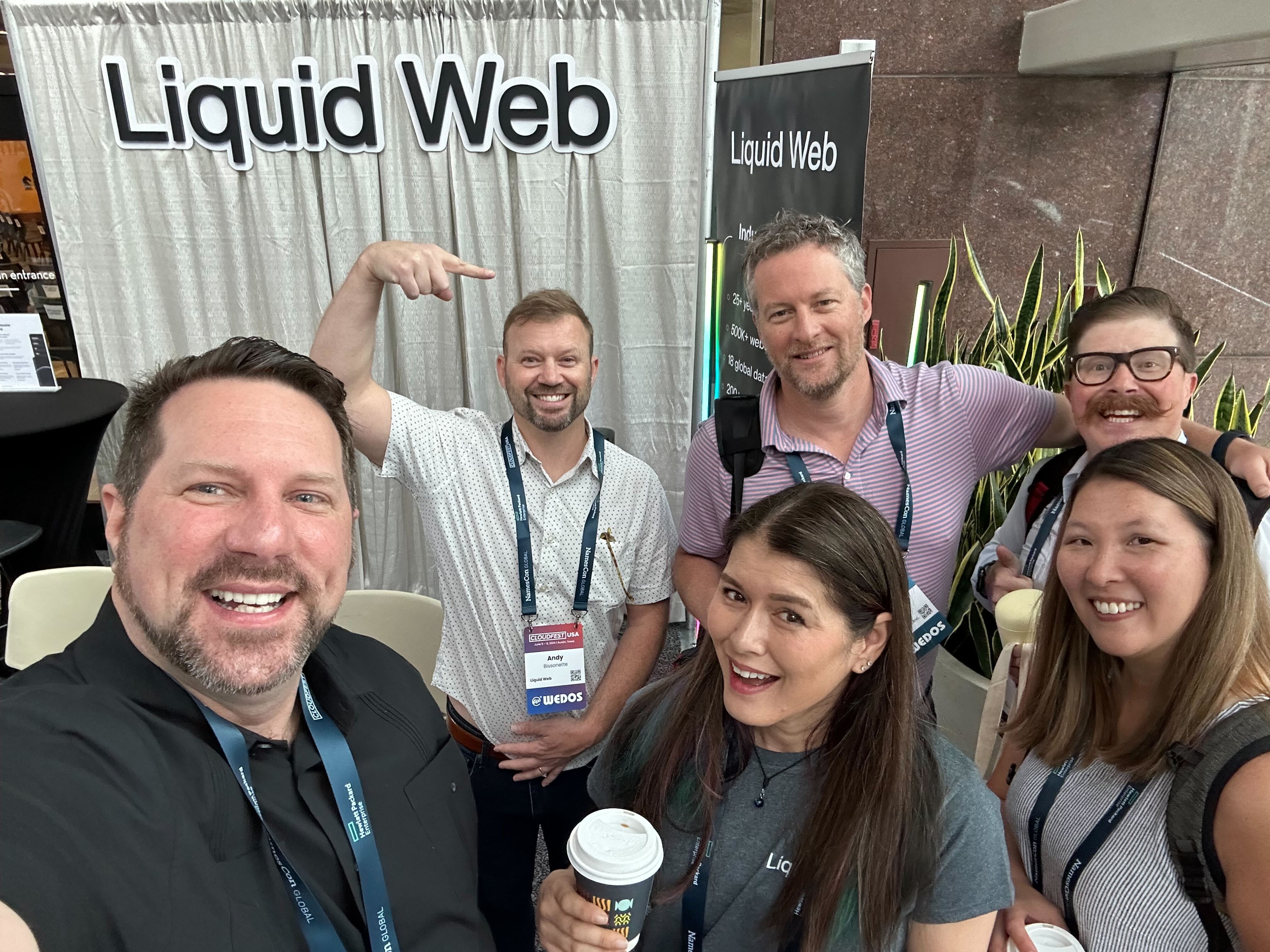 A few members of the Liquid Web team pose for a photo with friends at their booth