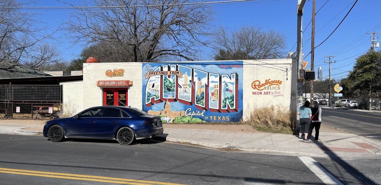 Graffity outside of an art gallery that says 'Greetings from Austin'