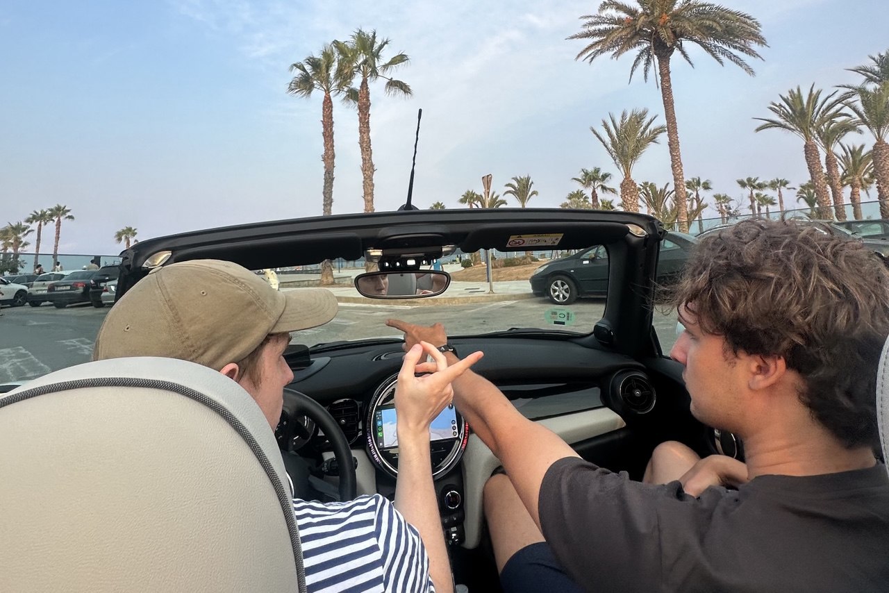 Ivan and his friend pointing to different directions in the car