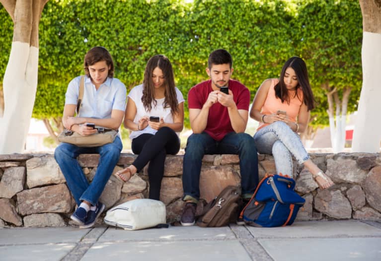 Jóvenes distraídos por sus teléfonos celulares