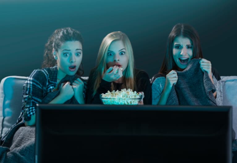 Tres chicas mirando una película de terror