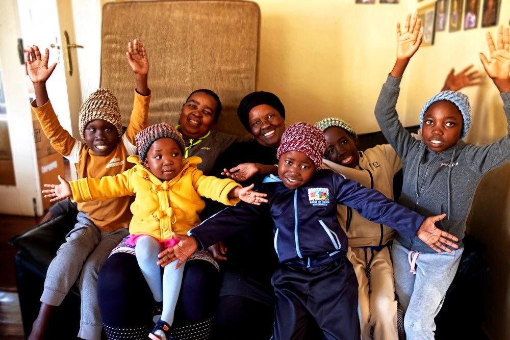 Children and caregivers at Marang House waving and celebrating together