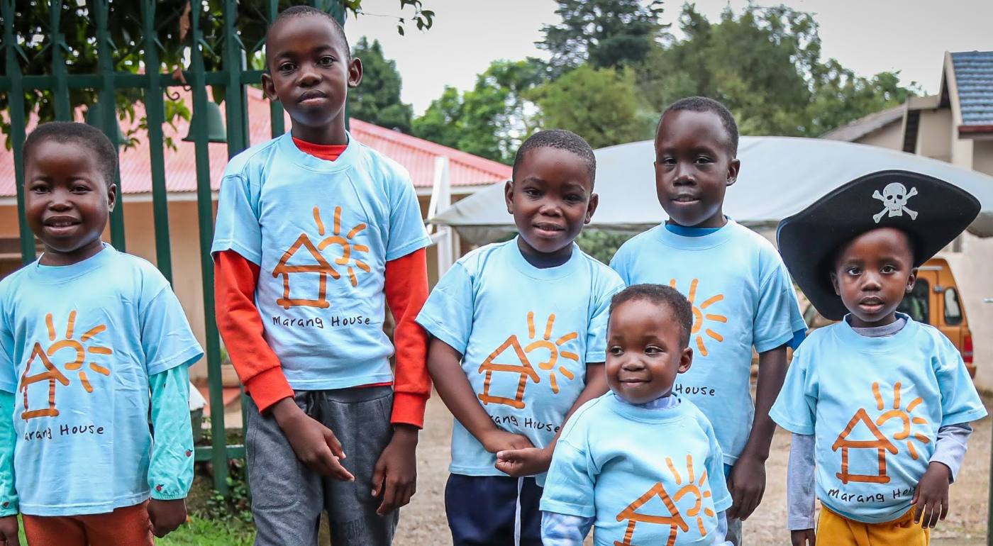 Children at Marang House wearing Marang House t-shirts, one in a pirate hat