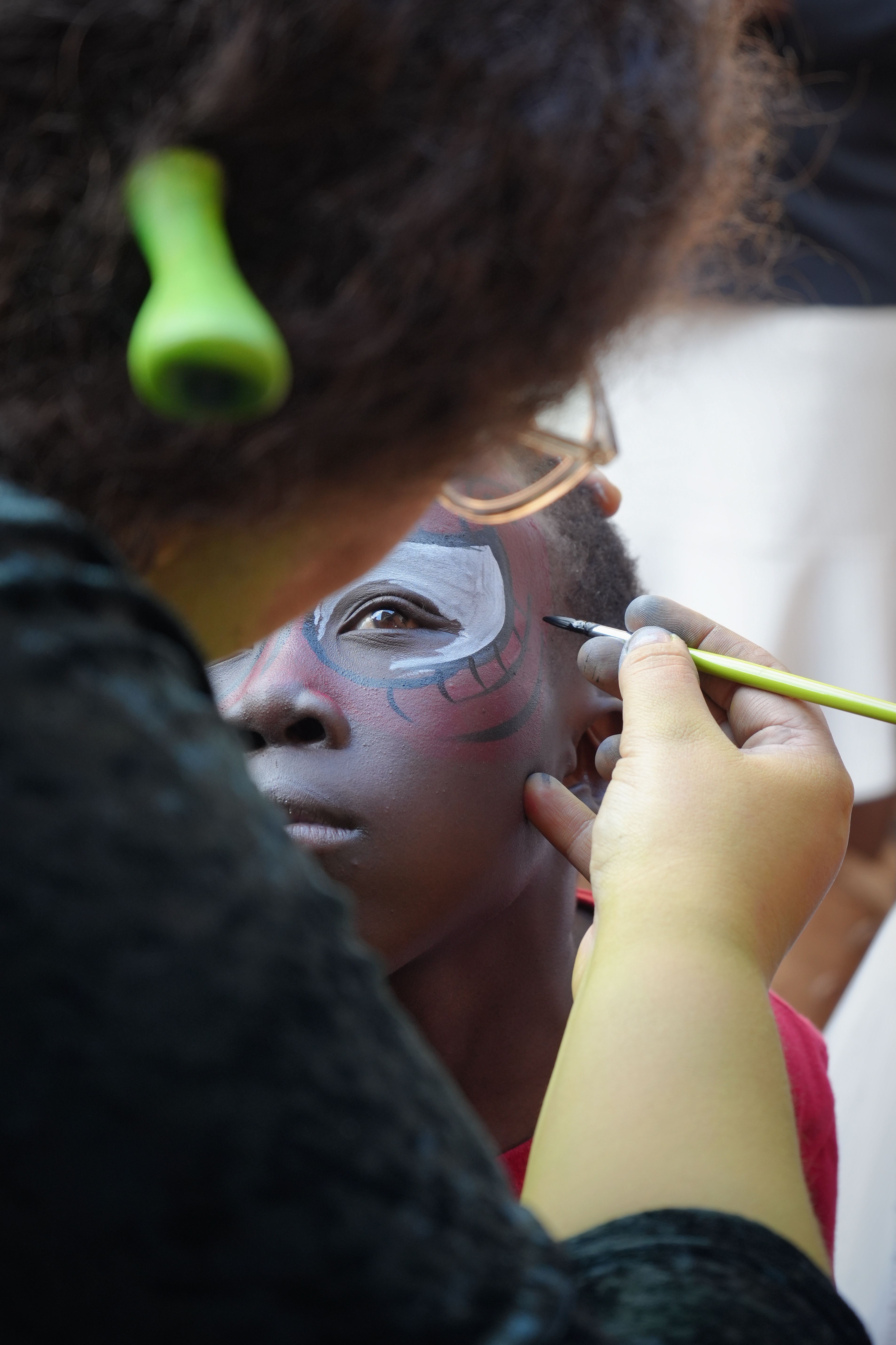 A child showing their face paint at Marang House Garden Day