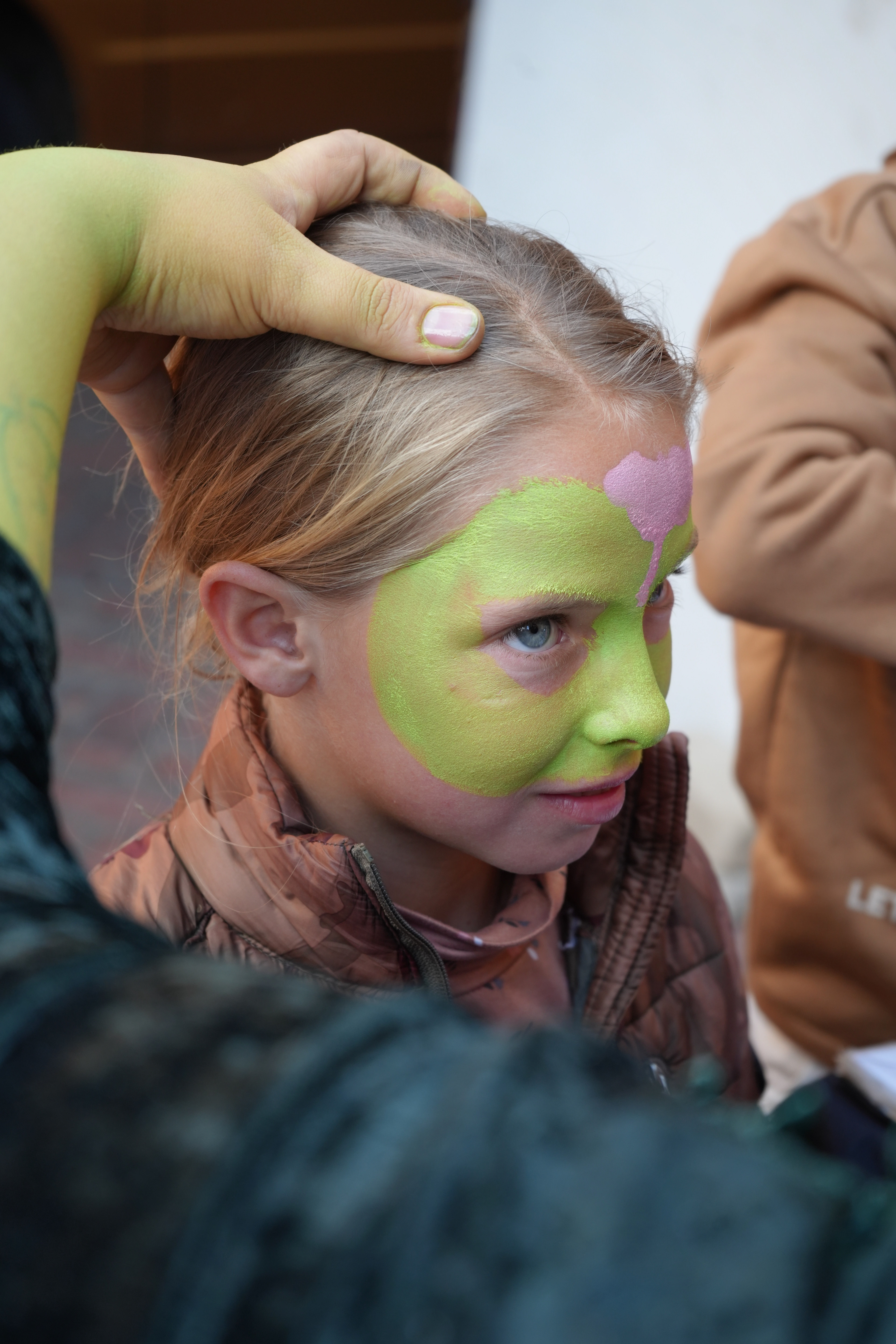 A child having face paint applied at Marang House Garden Day.