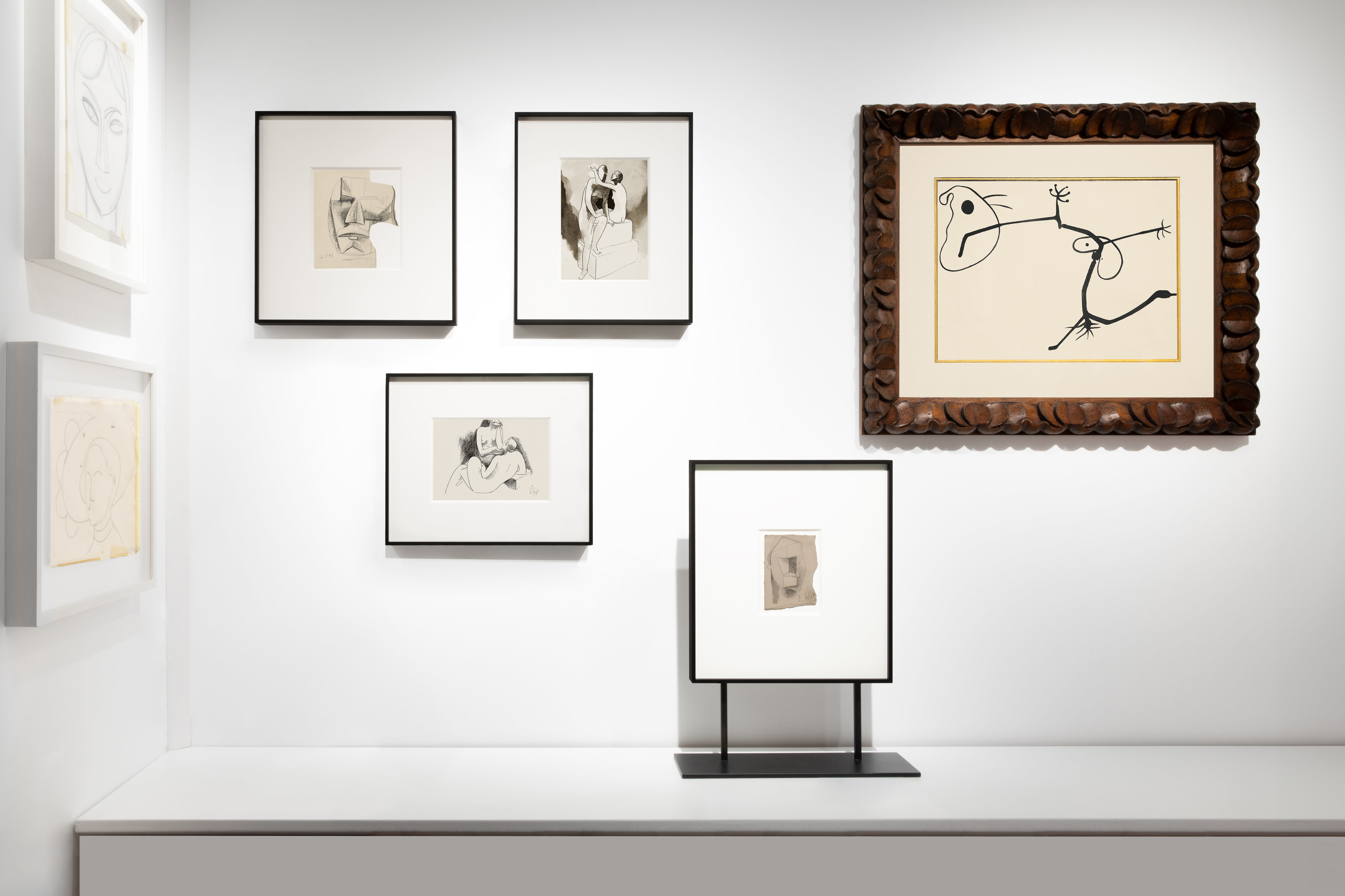 Installation view at Salon du dessin 2024 in Paris, with framed works clustered across two corner walls, including one framed work on a floor stand.