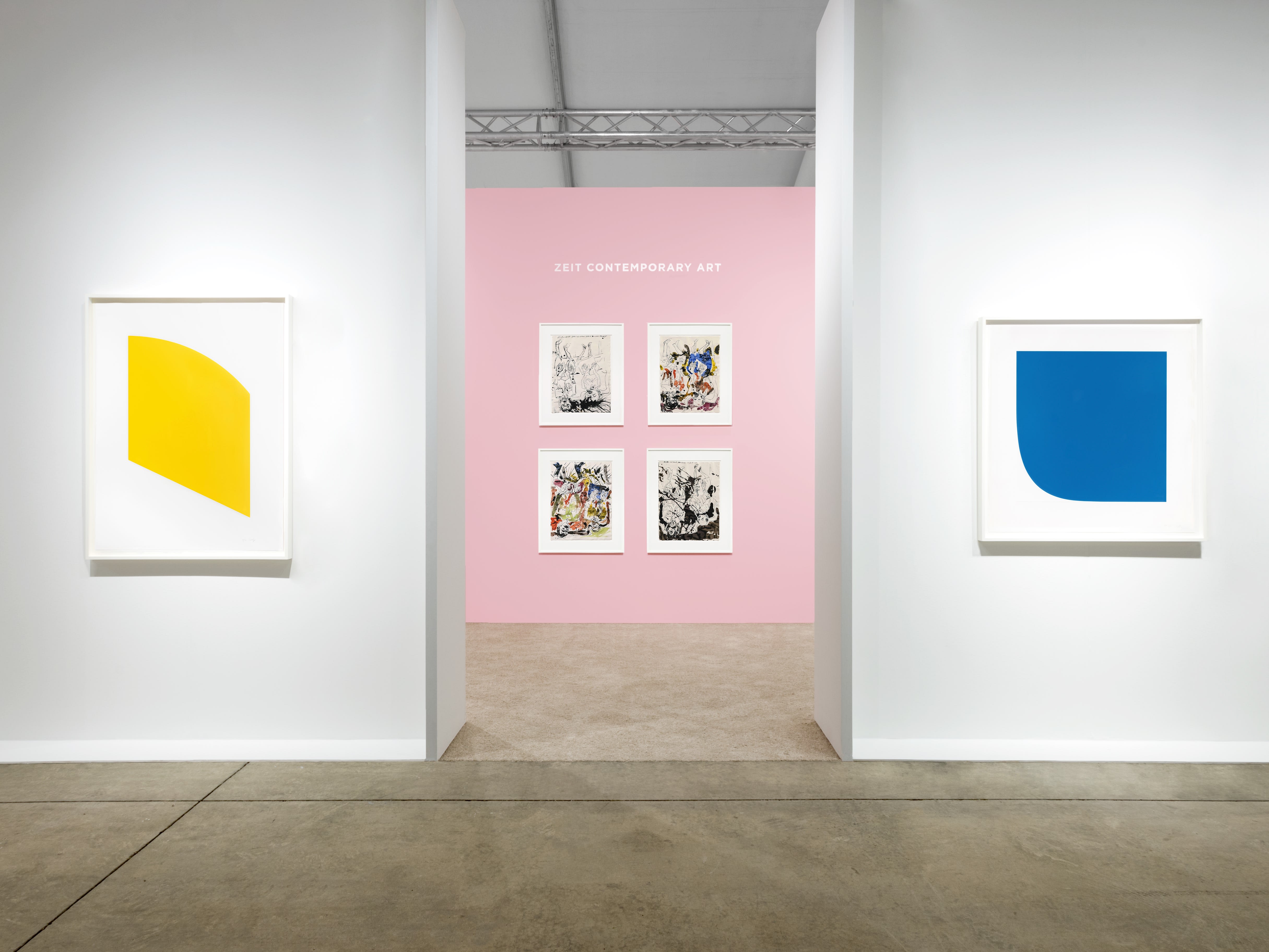 Installation view at Art Miami 2023 in Miami, with framed works displayed across several booth walls, including a grid on a pink accent wall.