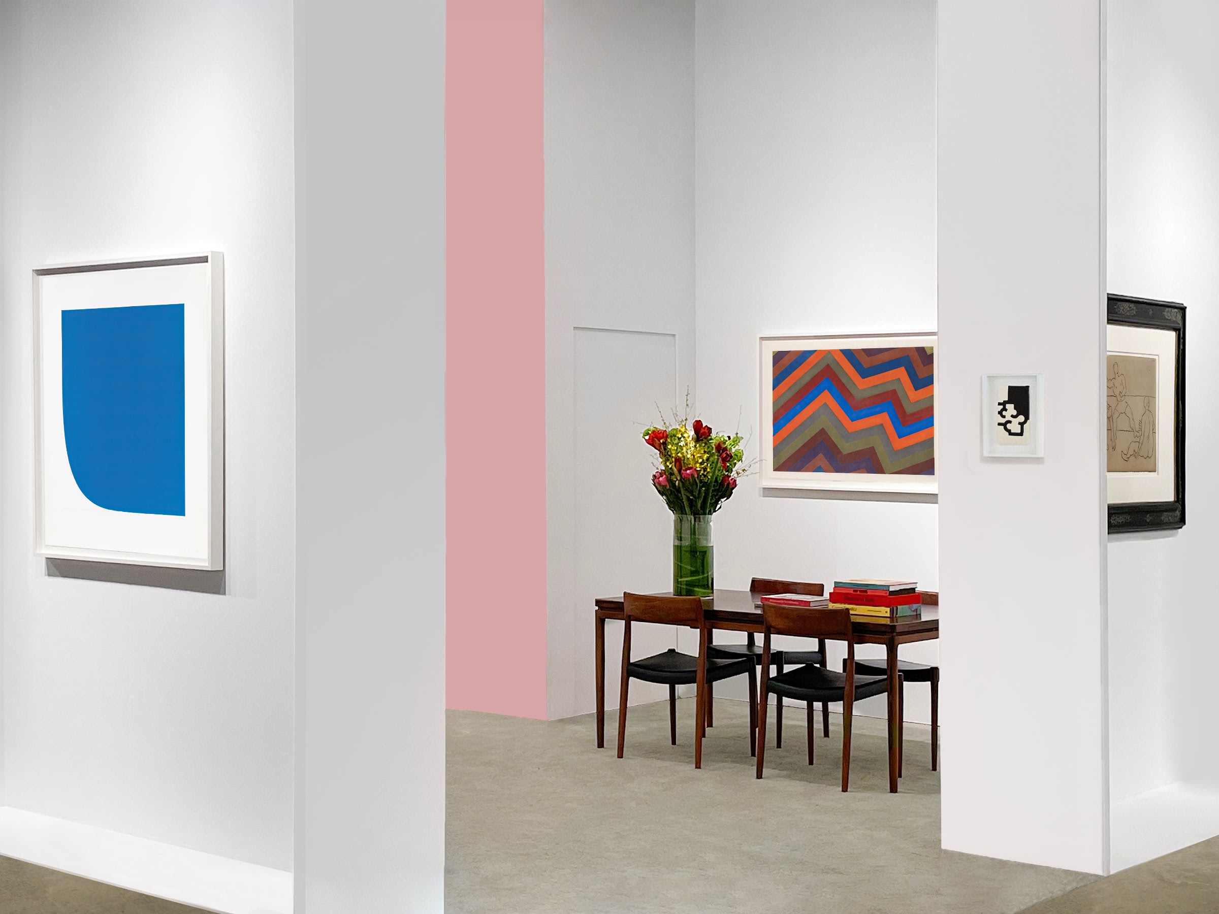 Installation view at Art Miami 2023 in Miami, with framed works visible through an open partition and a table with chairs in the foreground.