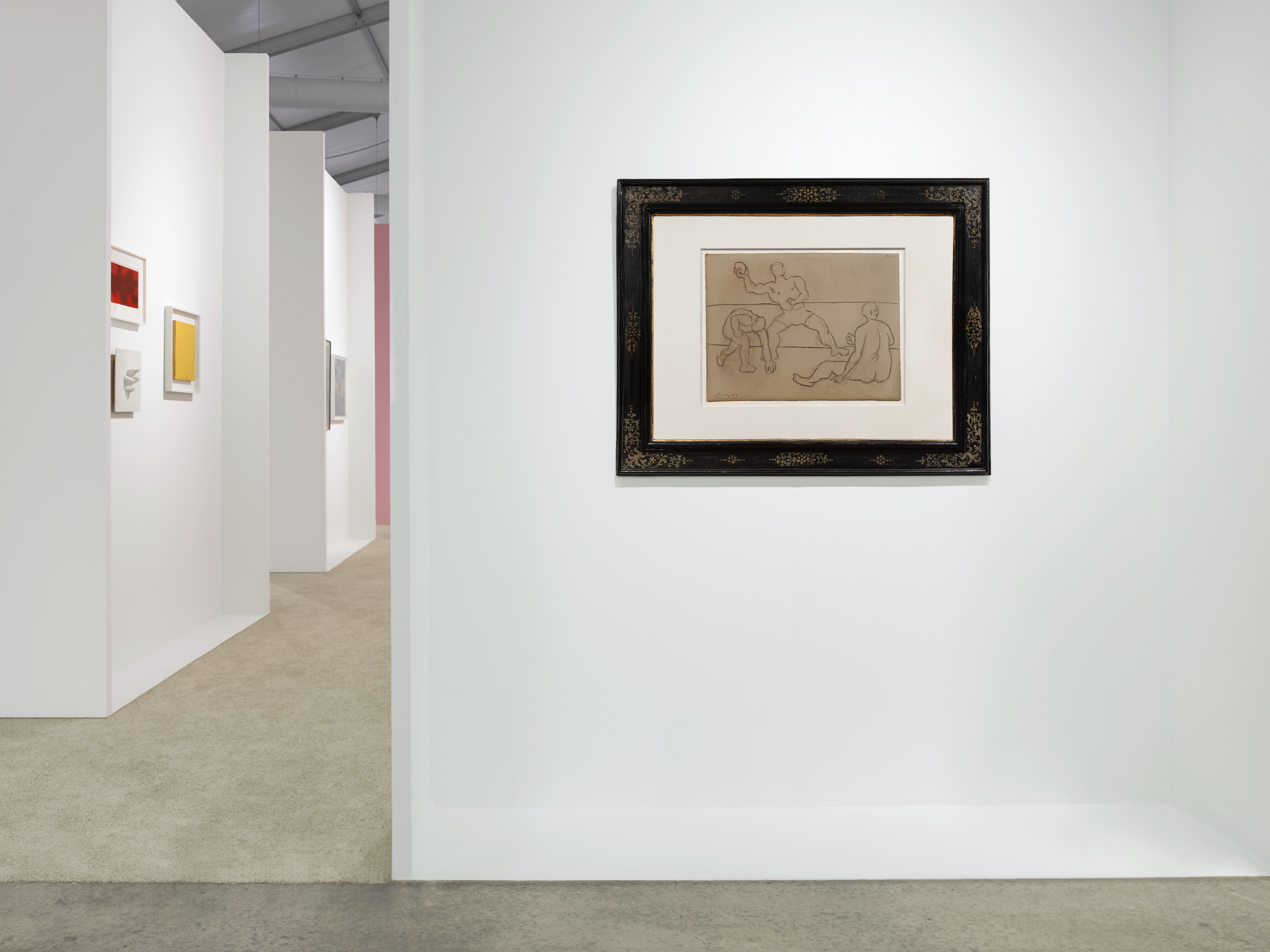 Installation view at Art Miami 2023 in Miami, with framed works along partitioned walls in a long corridor view through the booth.