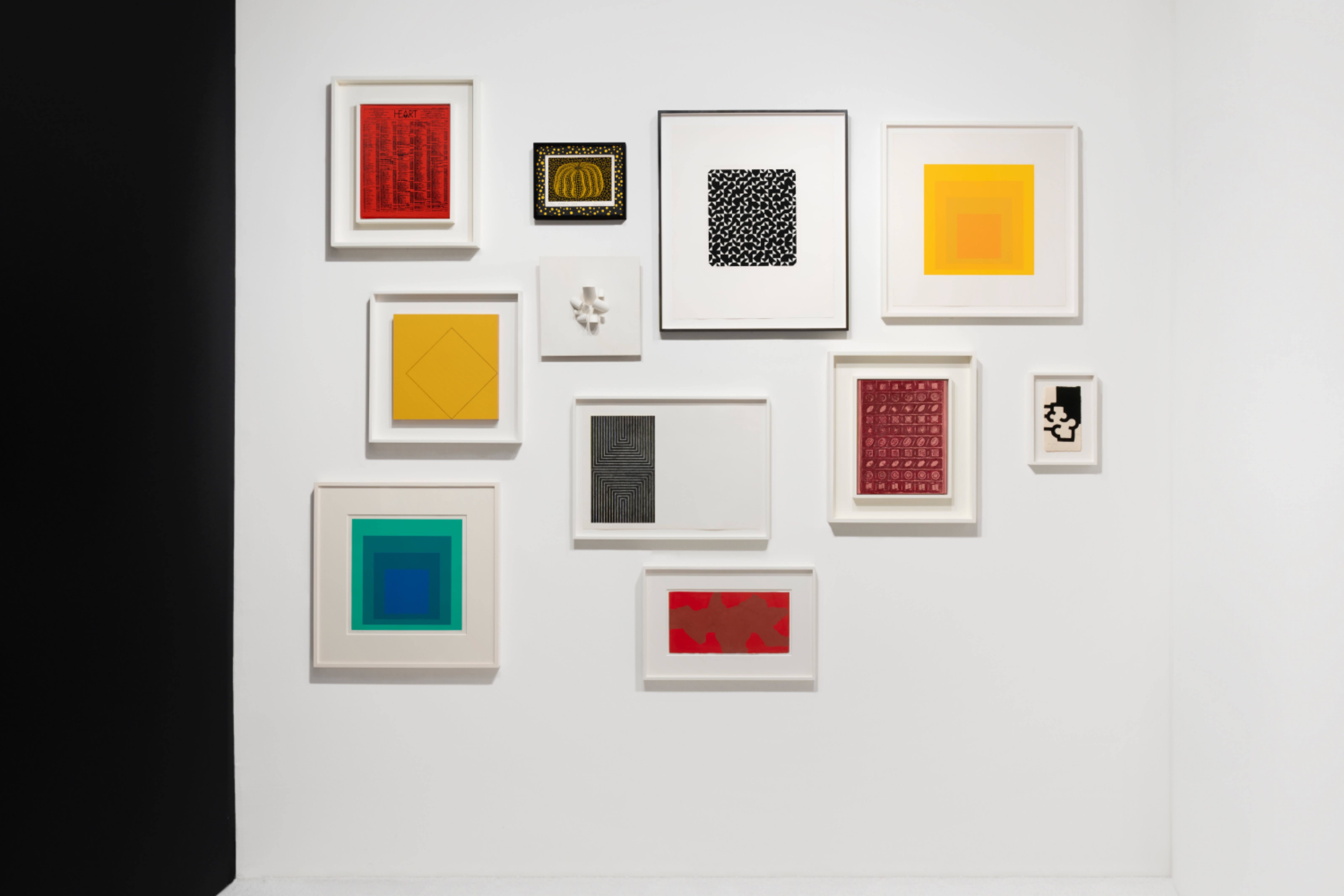Installation view at Salon Art + Design 2023 in New York, with a dense cluster of framed and three-dimensional works on a white booth wall.