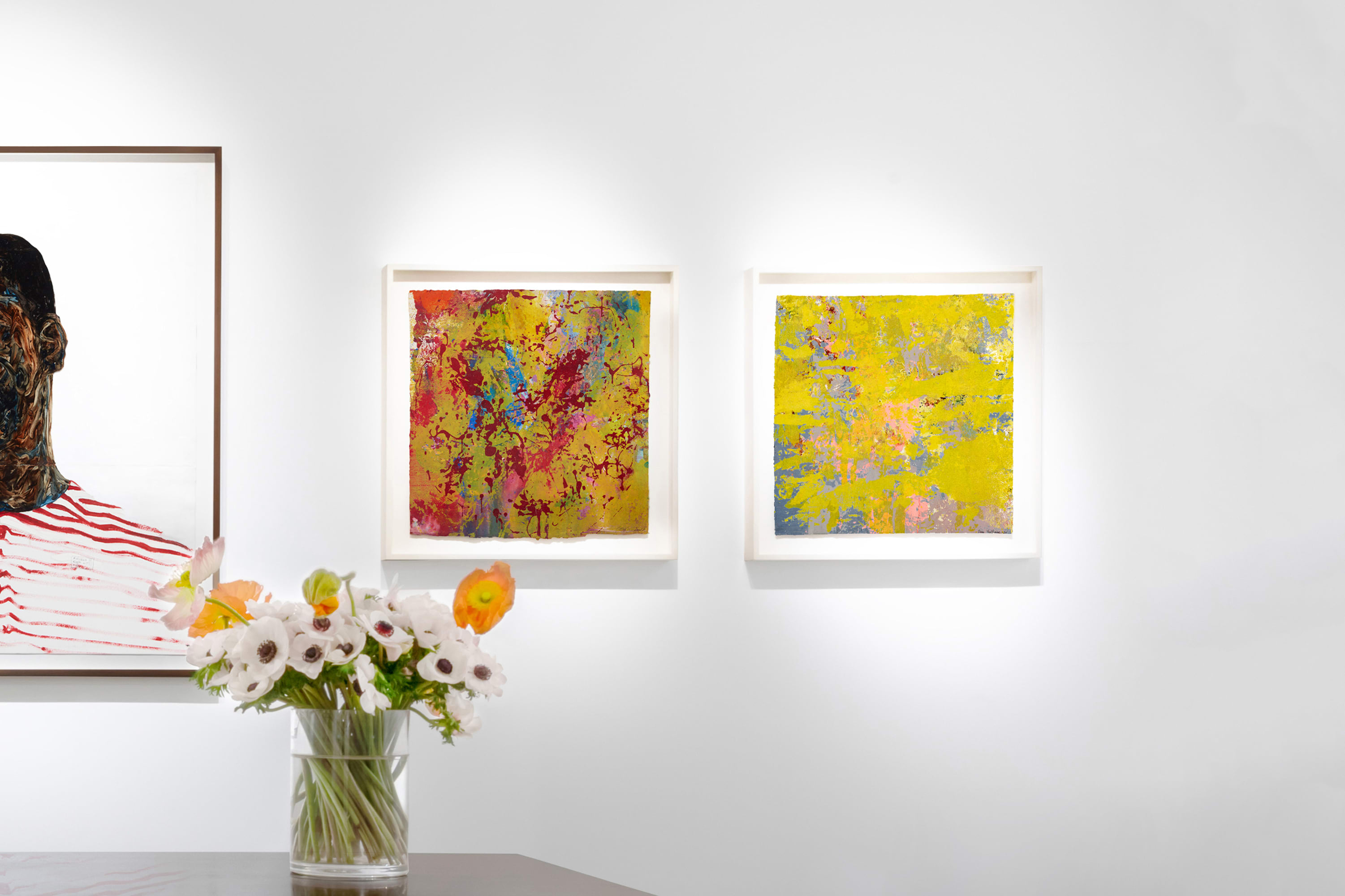 Installation view at Salon du dessin 2023 in Paris, with framed works arranged horizontally above a table with flowers in the foreground.