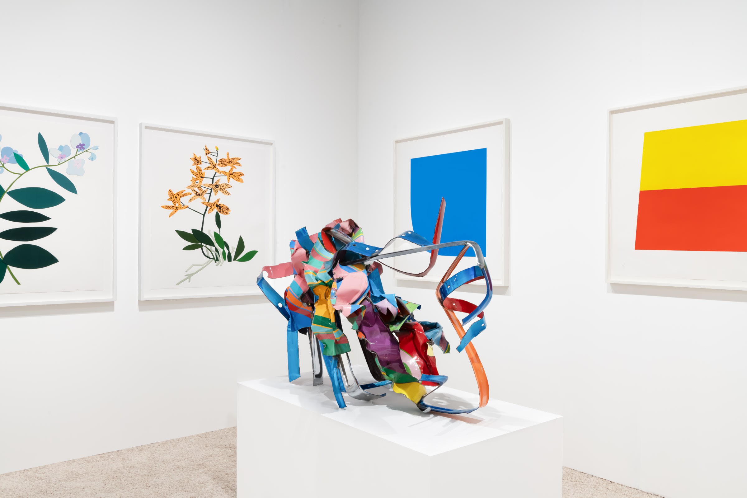 Installation view at Art Miami 2022 in Miami, with framed works across two corner walls and a floor-standing work displayed below.