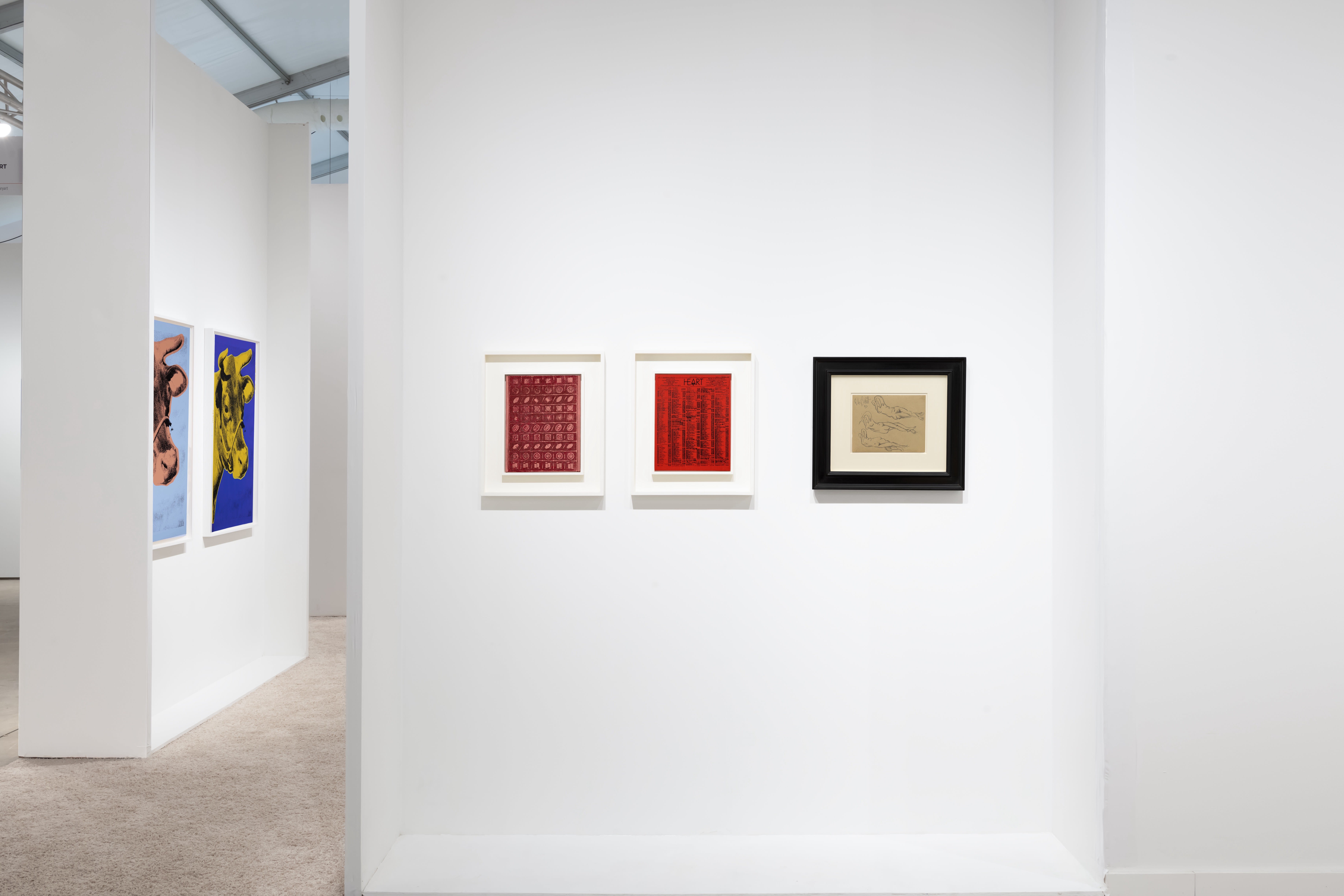Installation view at Art Miami 2022 in Miami, with framed works visible through an open partition across two separate wall sections.