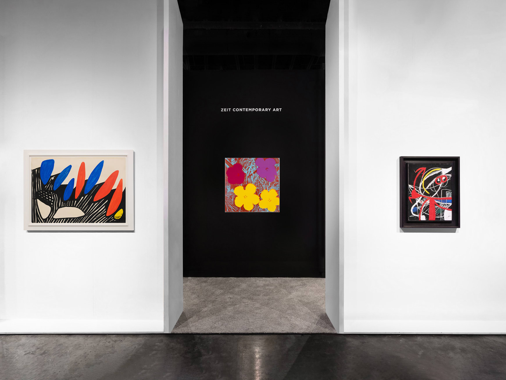 Installation view at Palm Beach Modern + Contemporary 2022 in West Palm Beach, with framed works displayed across several booth walls, including a dark accent wall.