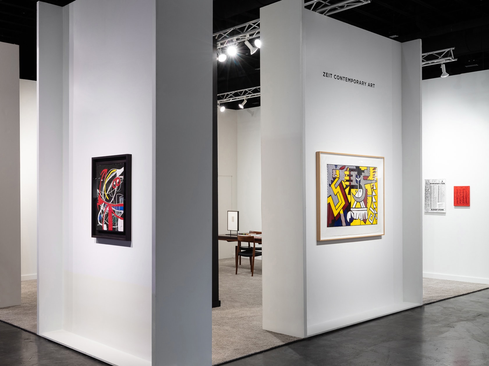 Installation view at Palm Beach Modern + Contemporary 2022 in West Palm Beach, with framed works on partition walls visible through an opening from the aisle.