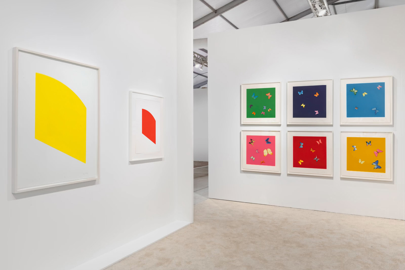 Installation view at Art Miami 2021 in Miami, with framed works on two adjacent booth walls, including a grid on one wall, in an open corner layout.
