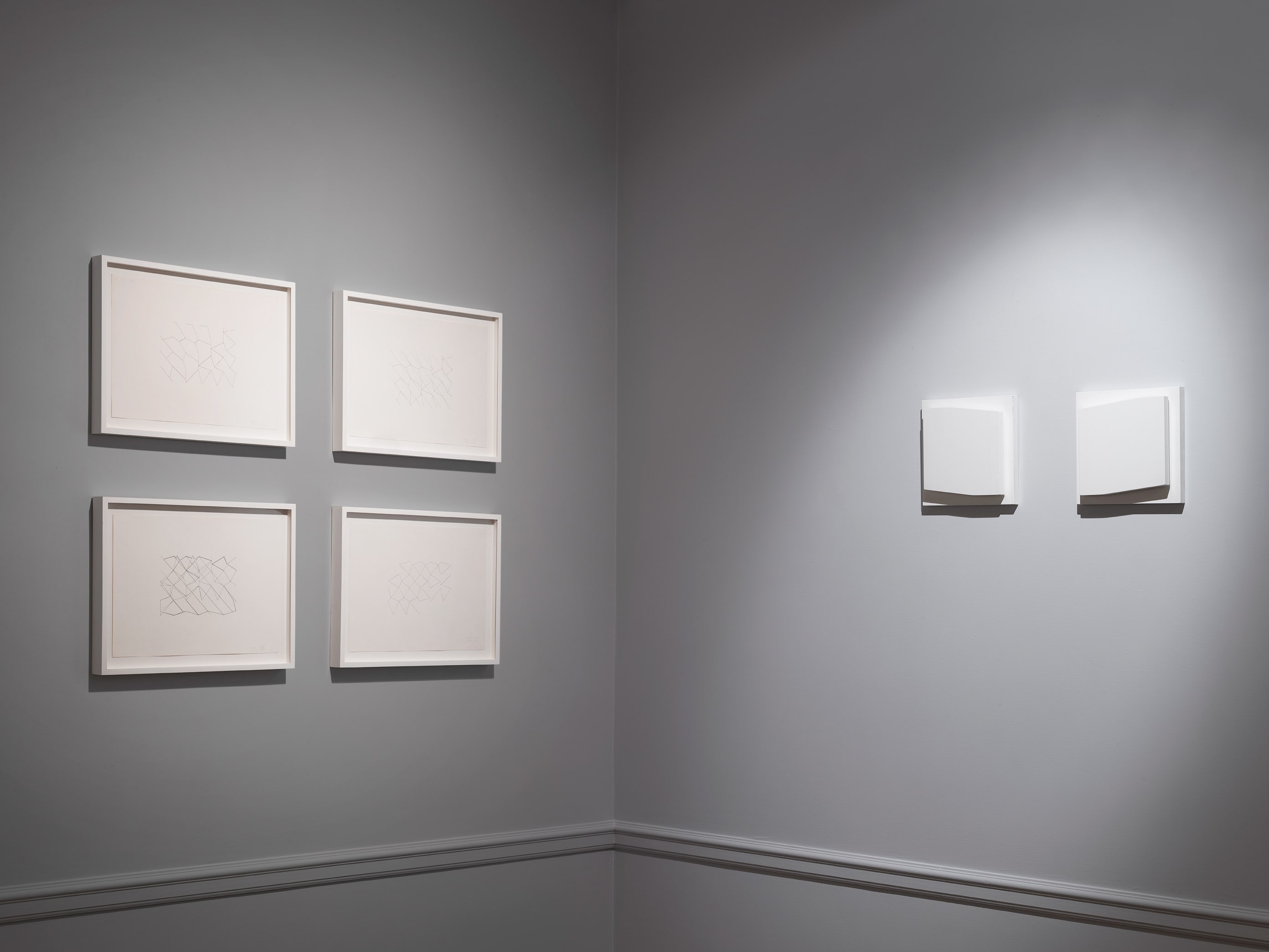 Installation view with four ink drawings by Elena Asins from 1978 on the left wall and a wood diptych by Asins from 2005 on the right wall.