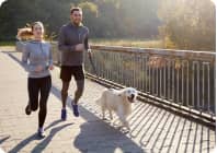 Man and woman running with dog