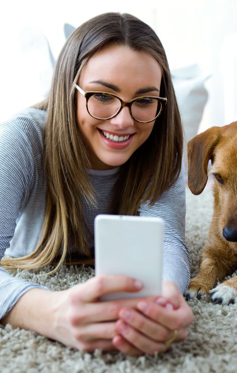Woman holds a phone on the floor with dog