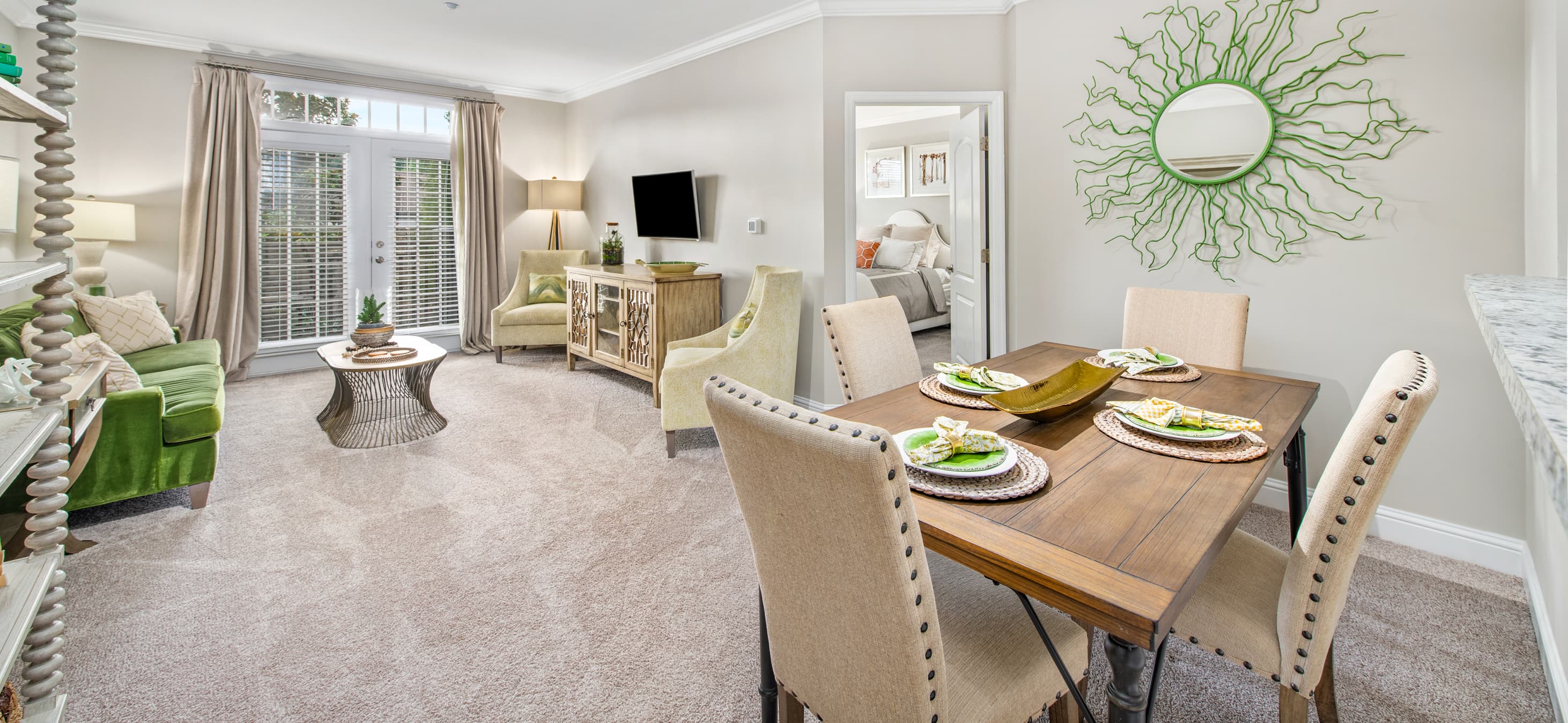 Dining area with dining table and chairs next to living space at MAA West Village luxury apartments in Smyrna, GA