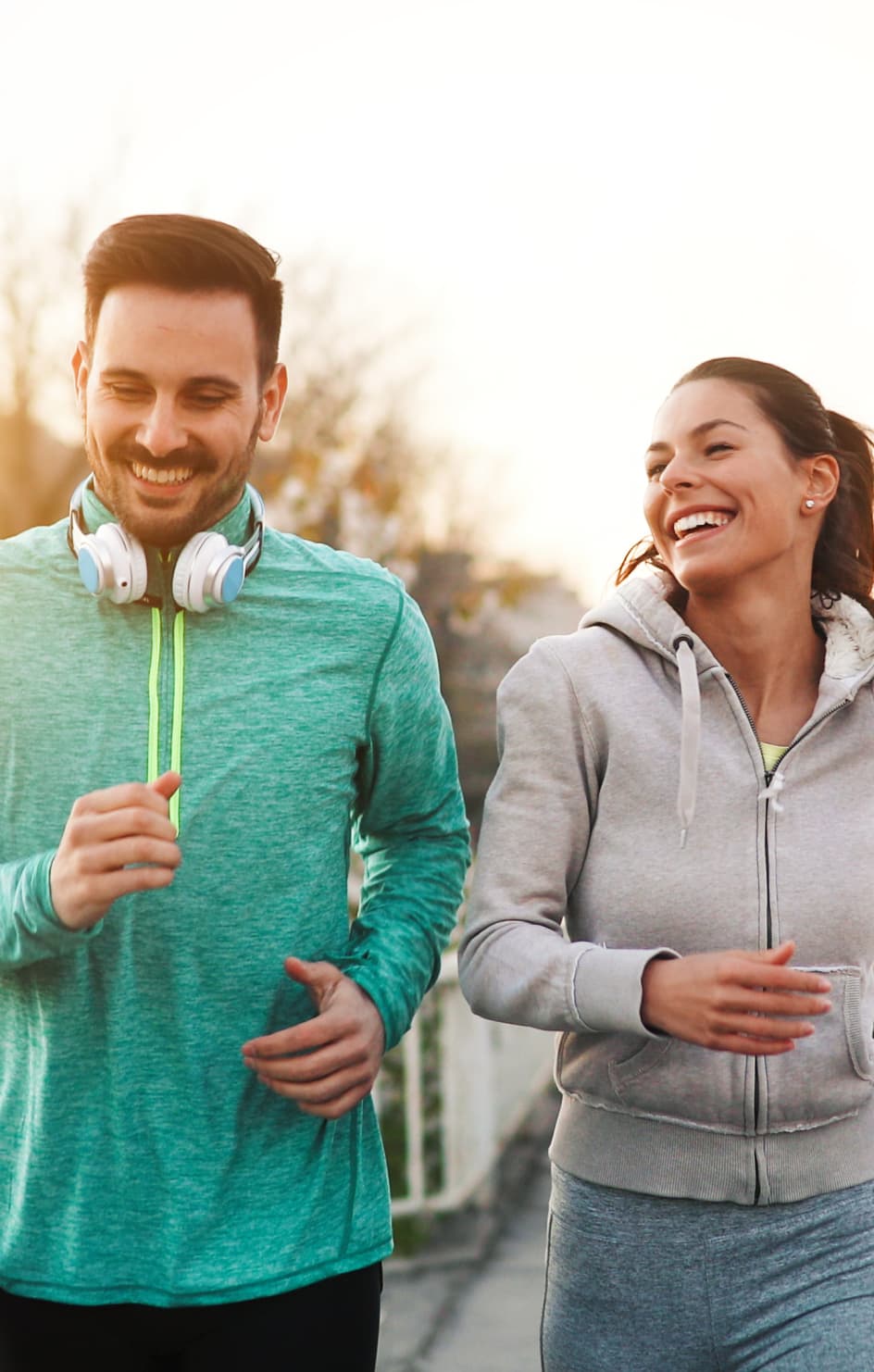 Man and woman run side by side smiling