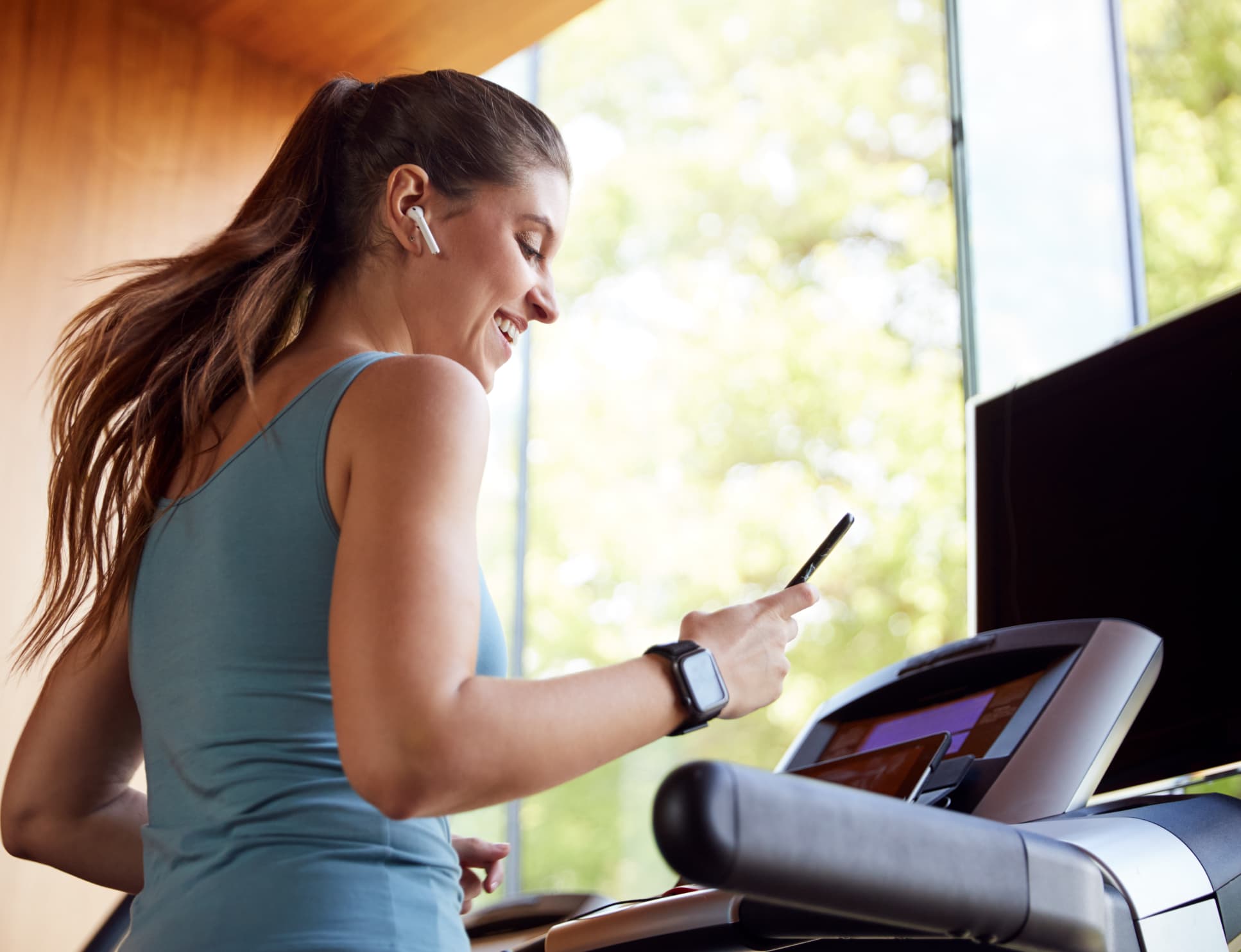 Woman on the treadmill checking her phone