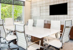 Conference table and white chairs and wall TV at MAA Centennial Park luxury apartments in Atlanta, GA