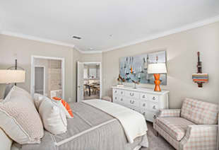 Second bedroom with white dresser and sitting chair at MAA West Village luxury apartments in Smyrna, GA