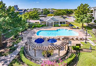 Swimming pool with lounge chairs at MAA Shoal Creek luxury apartments in Bedford, TX