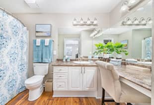  Spacious bathroom with patterned shower curtains, powder sitting area with large vanity mirrors at MAA Berkeley Lake luxury apartments in Duluth, GA