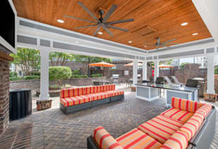 Poolside covered patio area with ceiling fans above plush sofas with multiple sitting areas at MAA Ayrsley luxury apartments in Charlotte, NC