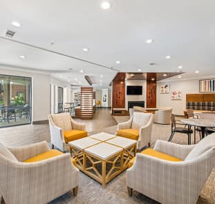 Community clubhouse with spacious lounge areas with sofas and coffee tables at MAA West Village luxury apartments in Smyrna, GA