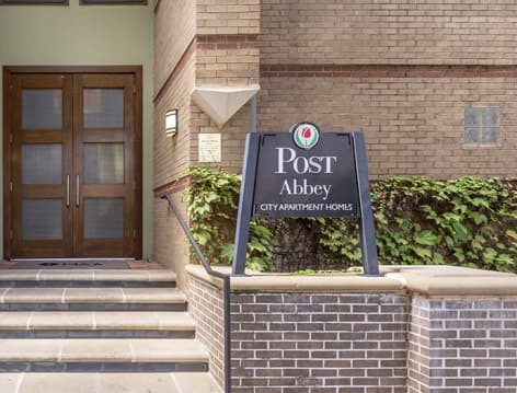 Exterior signage at Post Abbey luxury apartment homes in Dallas, TX