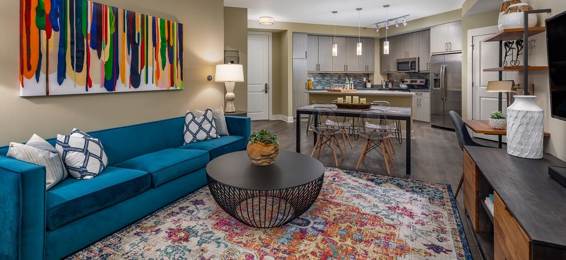 Open living space in model home with blue couch and coffee table at MAA Centennial Park luxury apartments in Atlanta, GA