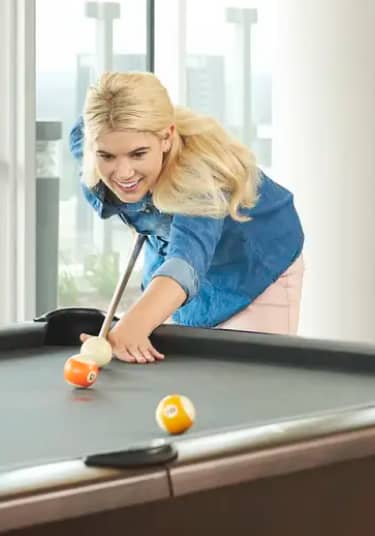 Blonde female playing at a billards table